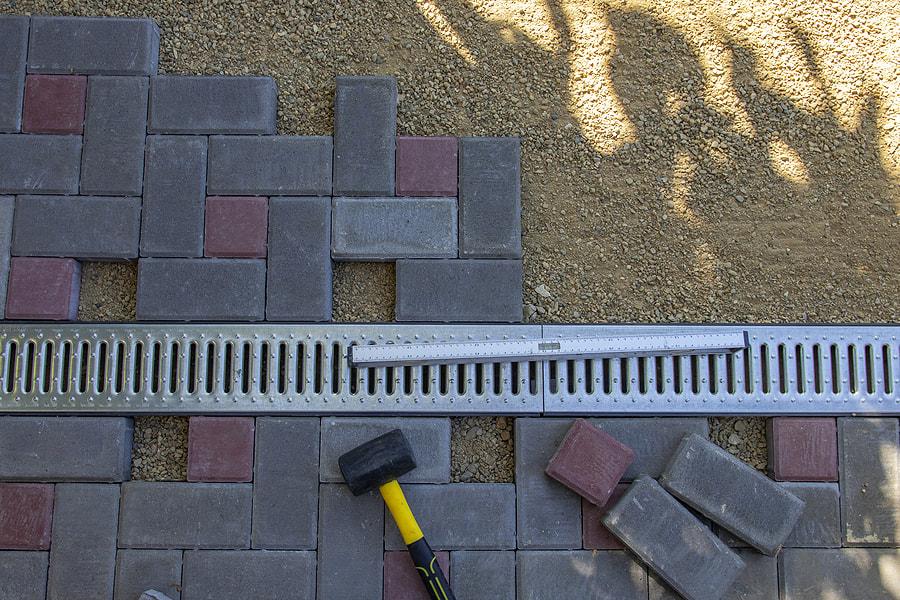 under installation of brick walkway beside the drainage